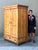 This stately antique Austrian armoire is a masterclass in European provincial craftsmanship, blending rustic warmth with...