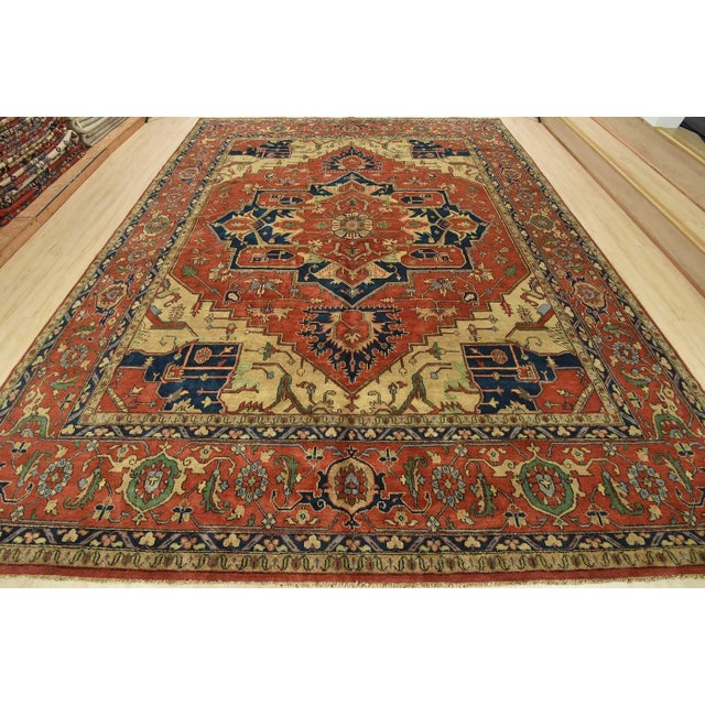 A traditional tribal Heriz rug hand-knotted with an all-wool pile on a cotton foundation. This oriental rug features a...