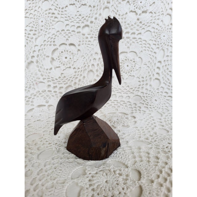 A hand carved wooden pelican figurine measuring 6 ¼” x 3 ½” x 3”’ base. Perfect for a coastal home or to give as a hostess...