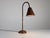 This table lamp was designed by French modernist Jacques Adnet in the 1950s. The tubular stem, round base, and conical...