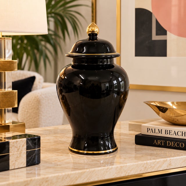 Elegant Haeger ceramic ginger jar featuring a glossy black finish accented with fine gold trim around the lid and base....