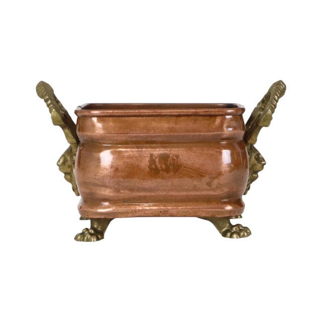 Antique square red copper and brass planter with two handles, claw feet, and lion-head motifs; late 19th century, France....