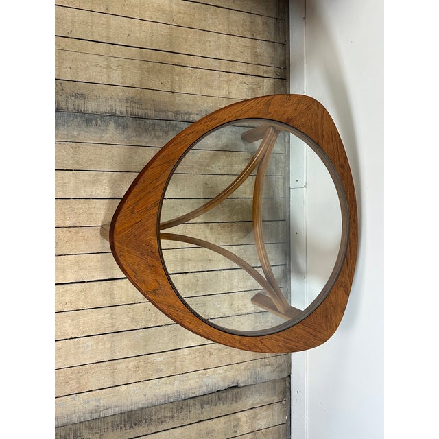 Tricester coffee table by Nathan, made of teak with a glass-topped inset, English vintage 1970s. Its aesthetic, with its...