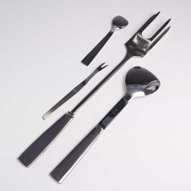 Collection of mid-century Italian modern flatware pieces crafted from stainless steel. The set features a sleek,...