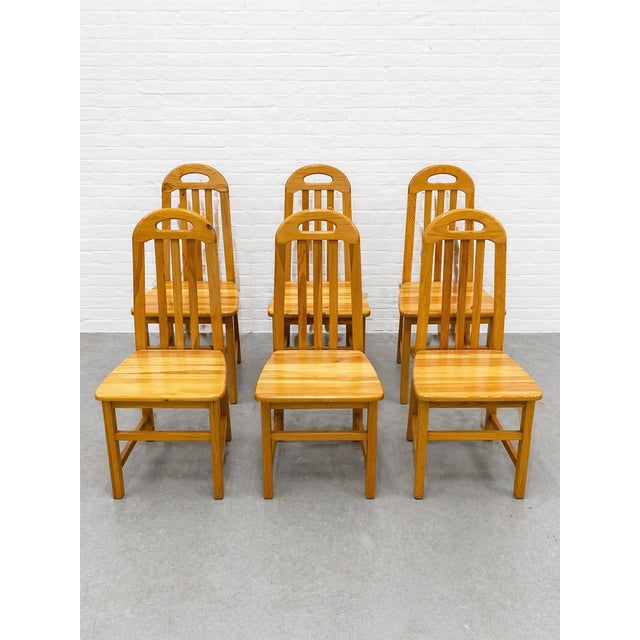 Set of six solid wood Scandinavian dining chairs featuring a clean slat back design and warm light oak tone. These chairs...