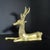 Vintage reclining deer sculpture has abstract ornaments on the deer's forehead and on its flanks above each leg; the...