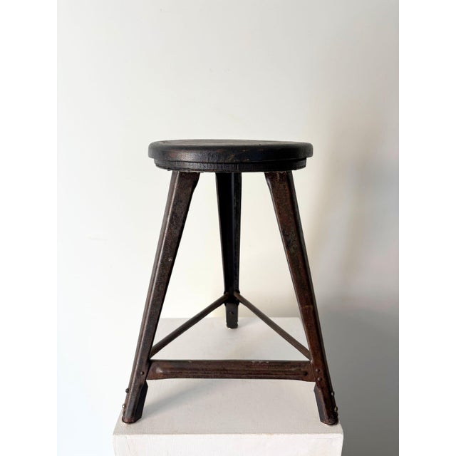A characterful vintage machinist’s stool with ebonised timber top and exposed rivets. This industrial piece has a circular...