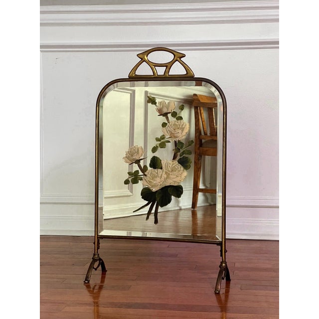 Art Deco period petite brass fireplace screen with a beveled mirror and hand-painted flowers, circa 1920. A charming...