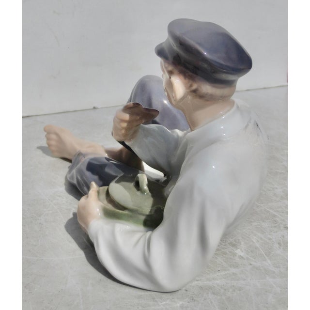 Royal Copenhagen by Christian Thomsen, dated 1956. Sheppard boy is having lunch. Very good condition. A young man with big...