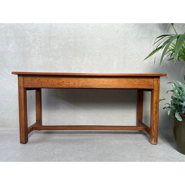 Old low table/bench in pitch pine. Equipped with 1 drawer on each short side. Comes from a school. Possibly a nursery...