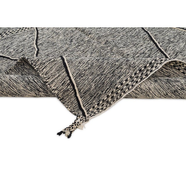 Bold ivory diamonds trace their way down a richly speckled charcoal-black ground, giving this handwoven rug the timeless...