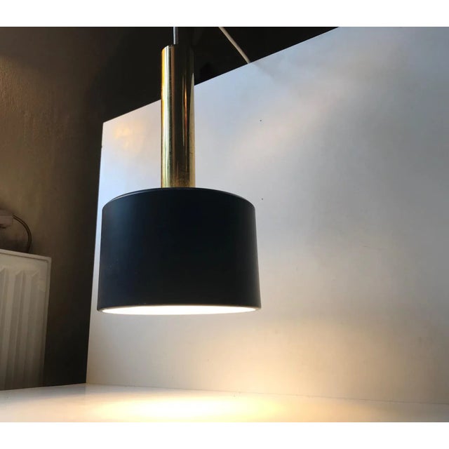 This Scandinavian pendant light made from brass and dark grey powder coated aluminium. At first glance it looks similar to...