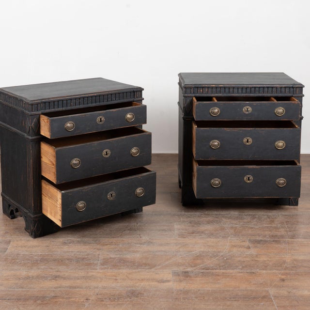 A pair of Gustavian pine chest of drawers with fluted side posts and upper dentil molding, all raised on decorative feet....
