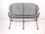 A iron and metal mesh Orange Slice loveseat in a satin black finish with sculptural designed seating area and legs . The...