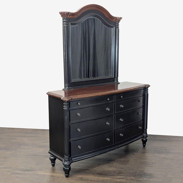 This elegant dresser features a sturdy black frame with a rich brown top and matching mirror. It offers nine spacious...