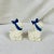 For consideration a pair of mid century dog form salt and pepper shaker. The dog are white and feature a blue bow.