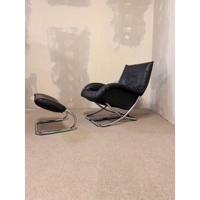 Robert Haussmann rocking chair with matching footstool from the 1980s, crafted from chrome and leather. This comfortable...