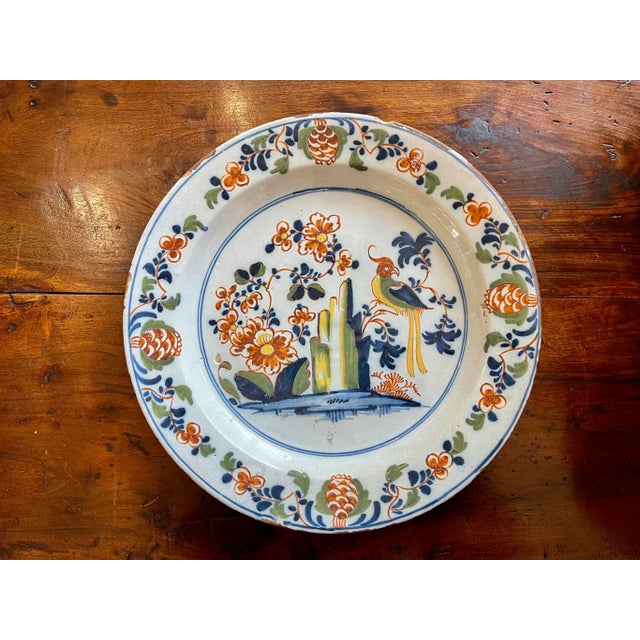 English Delft polychrome Delft Charger, having a parrot and other whimsical details, 18th century.