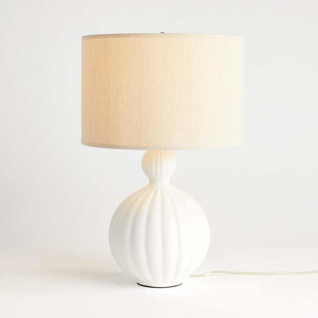 This brightWhite ceramic lamp is a modern take on a classic silhouette. The wellscaled shade and matte finish complete the...