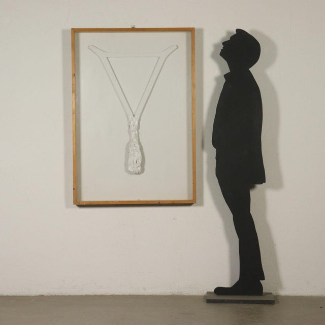 Bas-relief in wood, fabric and white tempera, evoking a stylised Crucifix. Mounted on a panel and presented in a display...