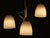 This original Art Deco chandelier consists of three arms at different heights, each featuring a white pate de verre tulip....