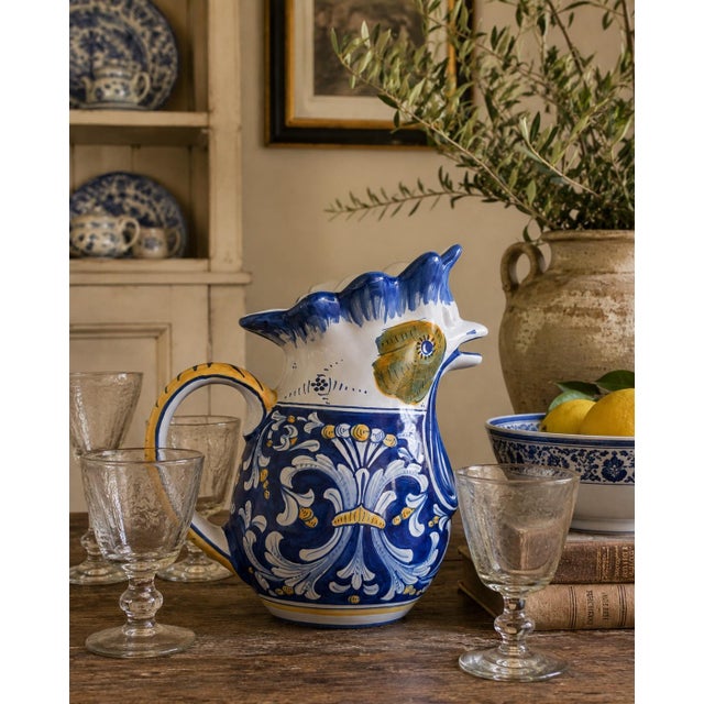 A spirited Italian faience pitcher by Cama of Deruta, modeled in the form of a chicken with an open beak serving as the...