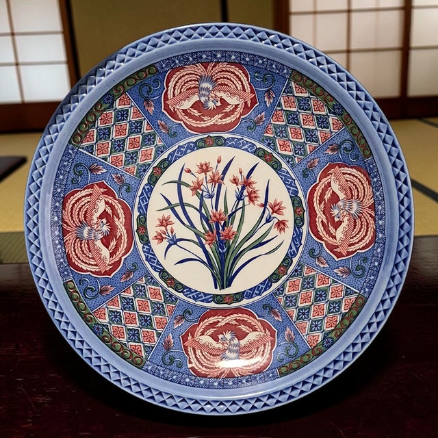 The product is a vintage Japanese Imari platter from the 1960s, featuring a beautiful floral and bird design. This piece...