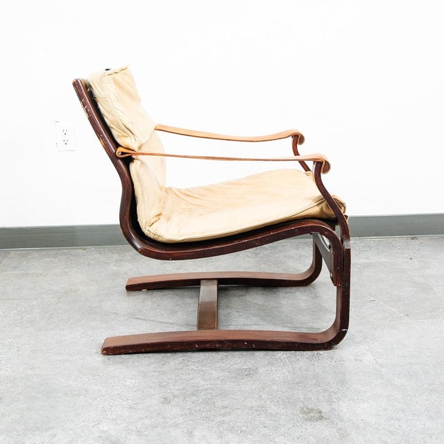 Tan sling lounge chair with saddle leather arms. Unsigned example. This piece was recently imported directly from Denmark.