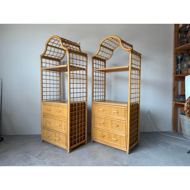 Beautiful vintage coastal-style etagères crafted in natural rattan and bamboo, featuring elegant pagoda-inspired crest...