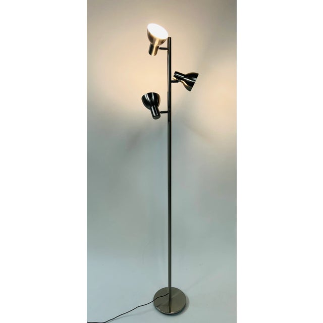 A modern three light chrome metal floor lamp with rotating lights. The floor lamp lighting system is adjustable allowing...
