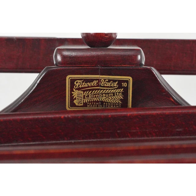 1950s Fitwell Valet 10 made of wood in a dark wood tone. Made by C. Birnbaum Ltd. in Germany. It is equipped with a...