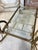 Bronze and brass bar cart, circa 1970. Double removable clear glass shelf. Openwork gallery. Original patina in its...