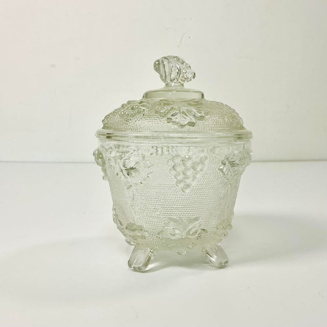 A lovely antique piece of Americana. This pressed glass lidded Candy Dish features botanical leaves, grape clusters and...