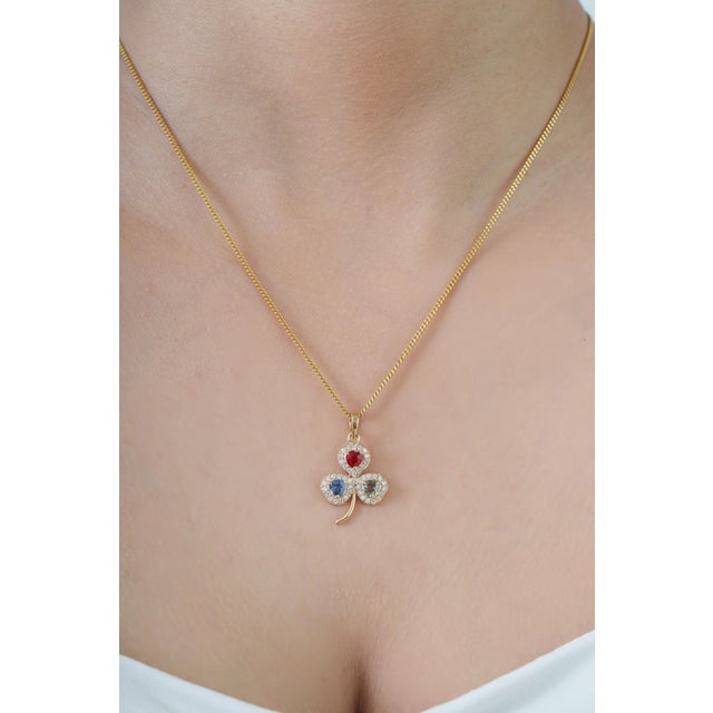 This charming clover-inspired pendant features 1.01 carats of natural multi sapphire, set in 14k yellow gold. Each...