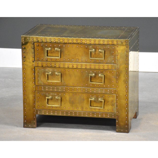 A brass clad Hollywood Regency bedside table nightstand by Sarreid Ltd. Excellent overall condition with beautiful patina....