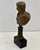 Bronze Bust of the Roman Emperor Tiberius, mounted on a fluted pedestal a a square wooden base, characterized by its...