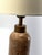 A substantial pink marble table lamp featuring dramatic natural veining and finely ribbed antiqued brass details. The...