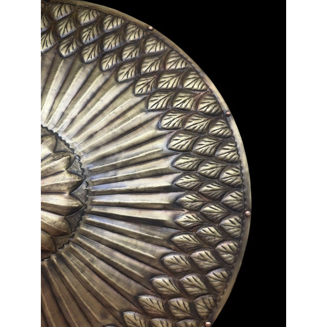 A handmade Turkish brass armor display featuring a domed helmet and round shield mounted on a matching pedestal stand....