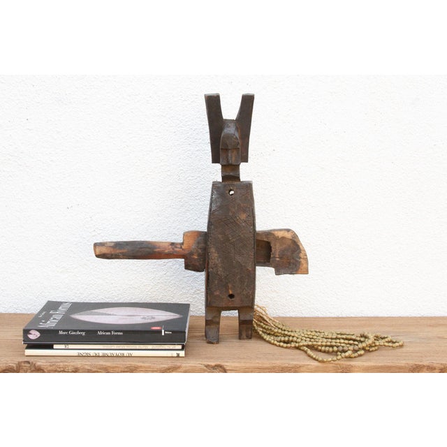 This antique tribal door lock, hand-carved from wood in Mali, Africa, is more than just a functional object; it's a...