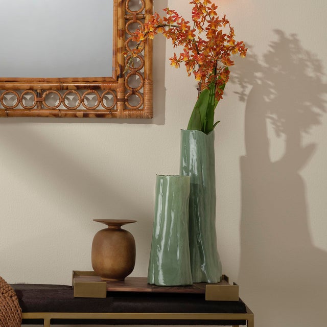 Expertly handcrafted of colored glass, the shape and nuanced details of this tall vase masterfully evoke the majesty of a...