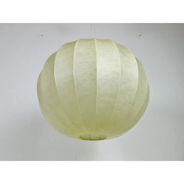 A cocoon hanging lamp made in Italy in the 1960s. It has a beautiful round design, which is similar to the lamps made by...
