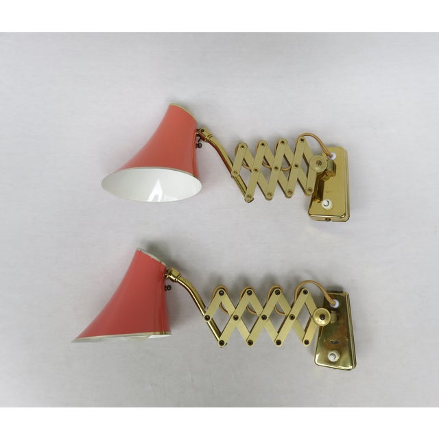 A pair of delicate scissor lights designed entirely in the design language and colors of the 1950s by SIS-Licht...