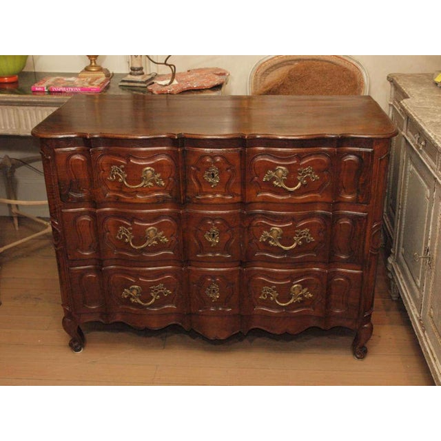 19th C French Arbalette Louis XV Walnut 3 Drawer Commode. Hand carved moulded drawer panels feature the brass period...