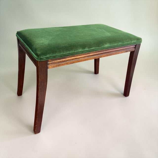 This is a pair of mid-century French Louis XVI style walnut and green velvet ottomans. The frames are a carved walnut and...