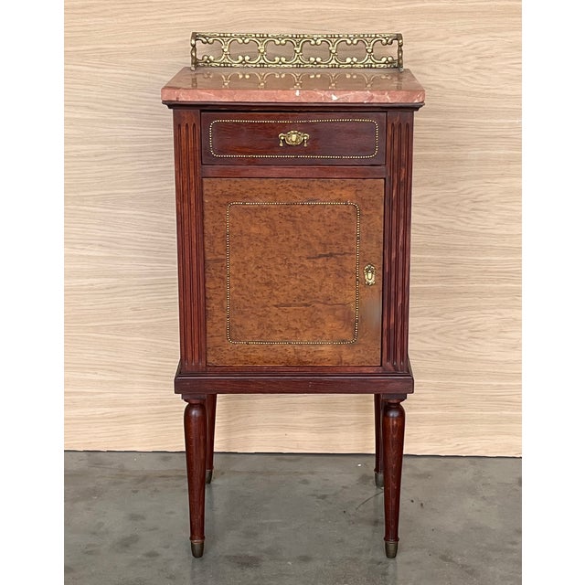 Pair of Italian Marquetry Nightstands with Bronze Crest, drawer and doors. Dimensions: Height: 36.62 in (93 cm)Width:...