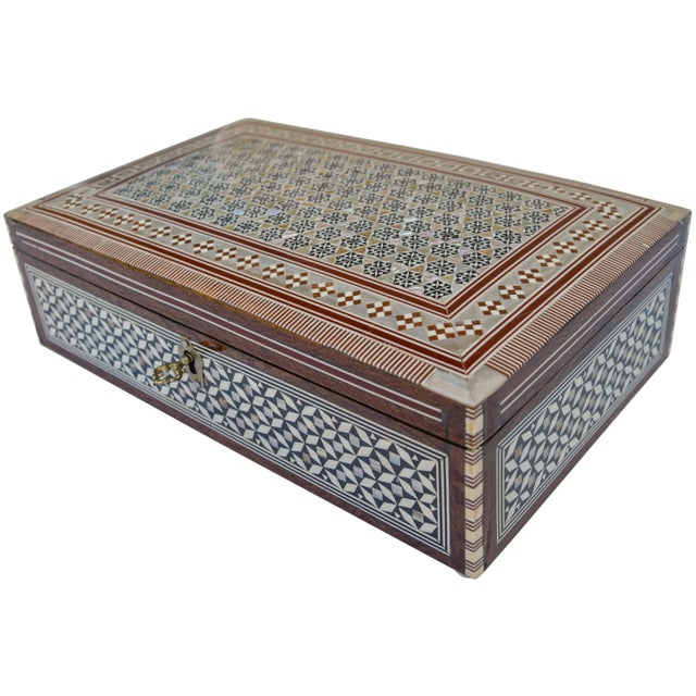 Exquisitely handcrafted mother-of-pearl inlaid wood box with key. Features an intricate display of fibulas for protection,...