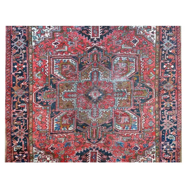 A wonderful early 20th century Persian Heriz rug with a traditional central large-scale floral patterned medallion amidst...
