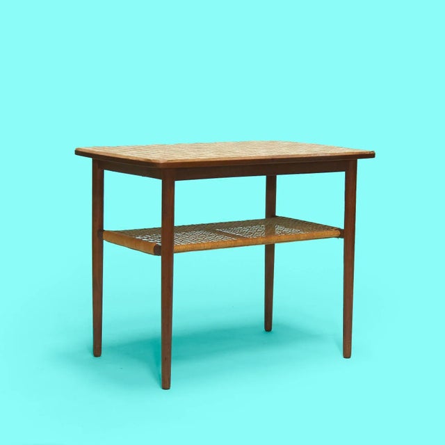 Mid-Century Danish tile top side table with rattan lower level made of teak frame and legs. With this tile top you don't...