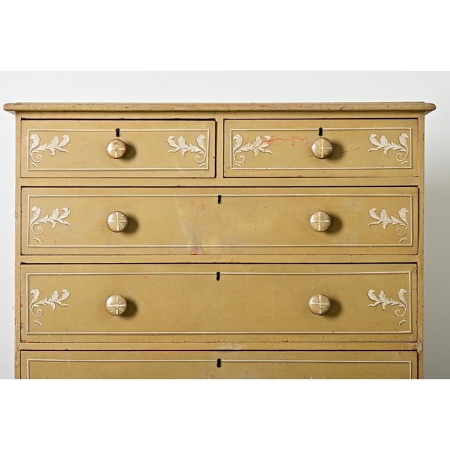 An English 19th century painted pine chest of drawers made in the Regency taste with delightful acanthus illustrations for...