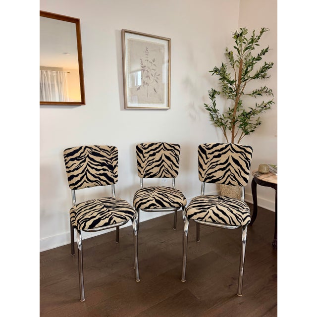A striking set of three vintage chrome dinette chairs, personally restored and reupholstered in bold tan-and-black tiger...